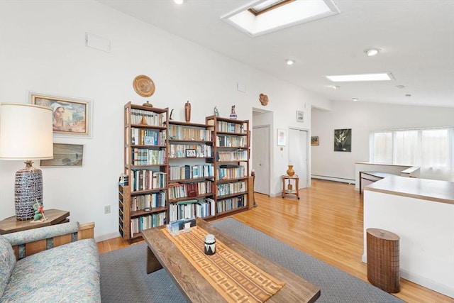 sitting room with lofted ceiling, recessed lighting, light wood-type flooring, and a baseboard radiator