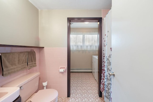 full bathroom with a wainscoted wall, toilet, a baseboard heating unit, tile walls, and vanity