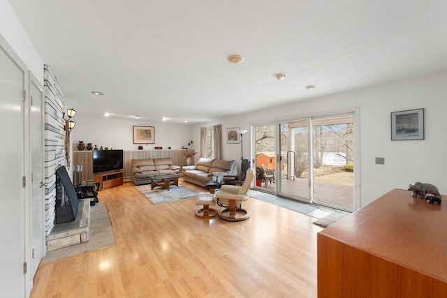 living area featuring light wood-type flooring and a fireplace