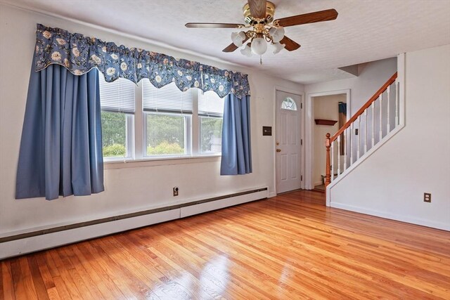 20 Amherst St, Grafton, MA 01536 - foyer entrance featuring a baseboard radiator, ceiling fan, wood-type flooring, stairs, and baseboards