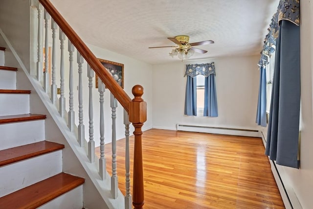 20 Amherst St, Grafton, MA 01536 - foyer entrance with a baseboard heating unit, wood finished floors, a ceiling fan, stairs, and a textured ceiling