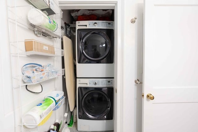 clothes washing area with stacked washer / dryer