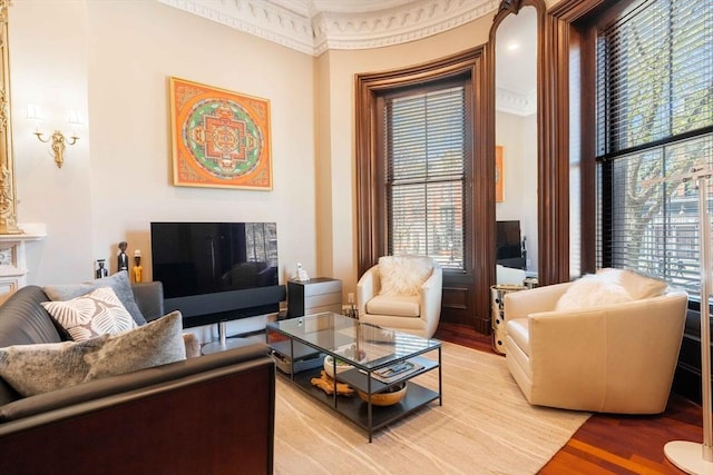 living room with a wealth of natural light, light hardwood / wood-style floors, and ornamental molding