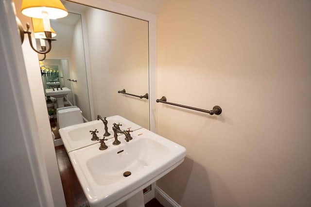 bathroom featuring sink, wood-type flooring, and toilet