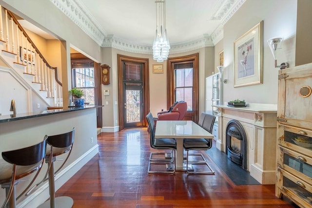 dining space featuring dark wood-type flooring and ornamental molding