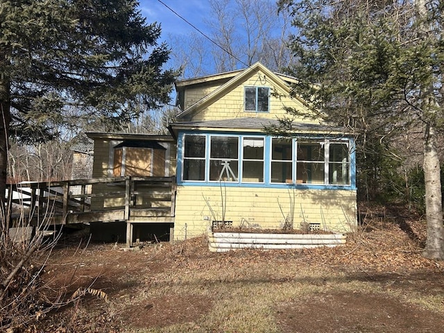 view of side of home with a sunroom and a deck