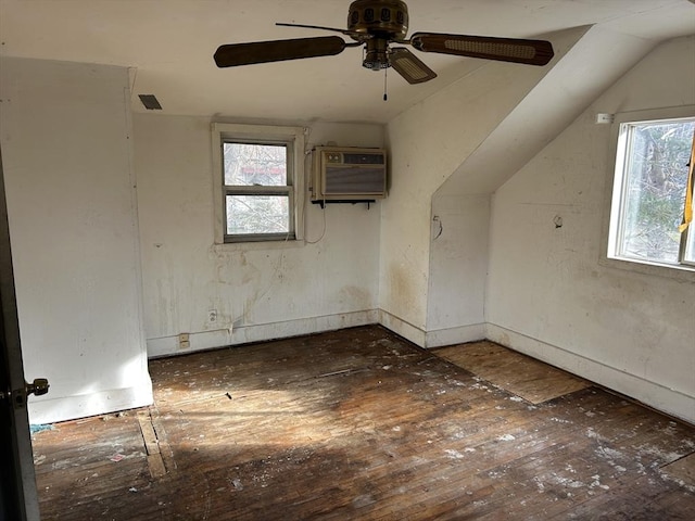 additional living space featuring a wall mounted air conditioner, dark hardwood / wood-style flooring, vaulted ceiling, and ceiling fan