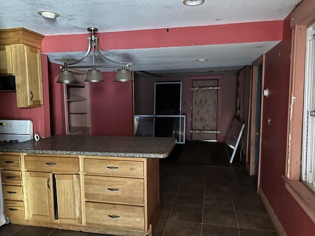 kitchen with kitchen peninsula, pendant lighting, dark tile patterned flooring, and white range with gas cooktop