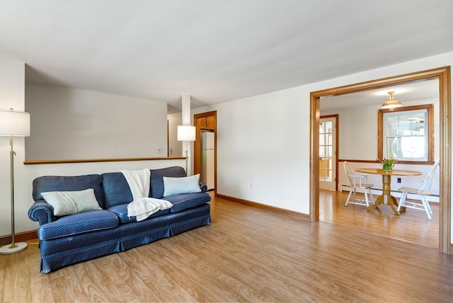 living room with light wood-style floors, baseboards, and baseboard heating
