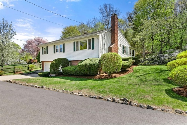 view of front facade with fence, a garage, a front yard, a chimney, and driveway