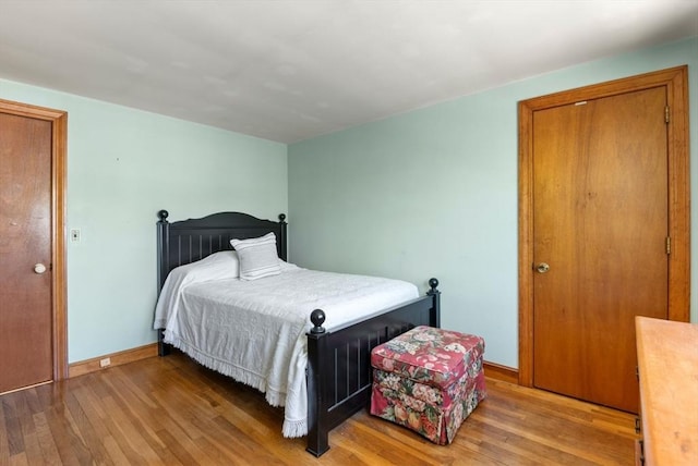 bedroom featuring baseboards and light wood finished floors