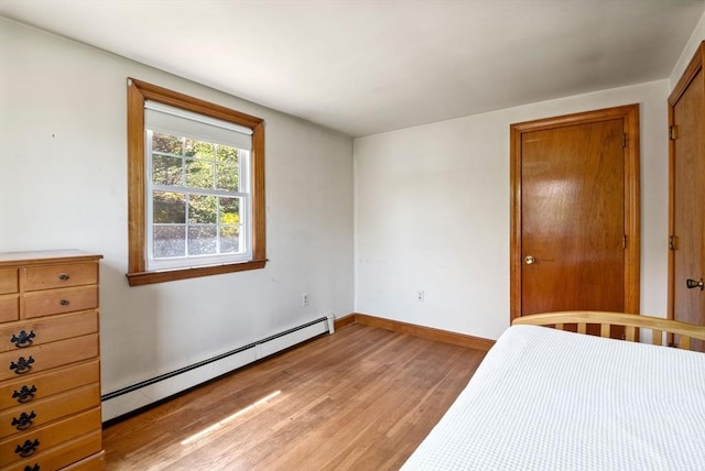 unfurnished bedroom with light wood-style floors, baseboards, and a baseboard radiator