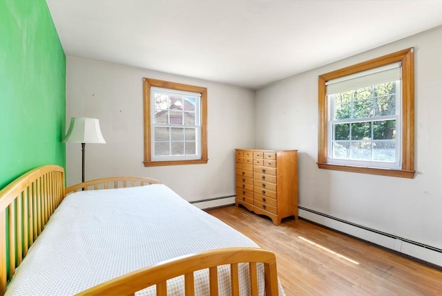 bedroom featuring a baseboard radiator and light wood-style flooring