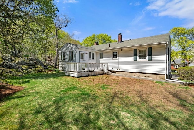 back of house with a lawn, a wooden deck, and a chimney