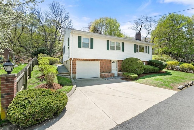 view of front of home with a garage, a front yard, a chimney, brick siding, and concrete driveway