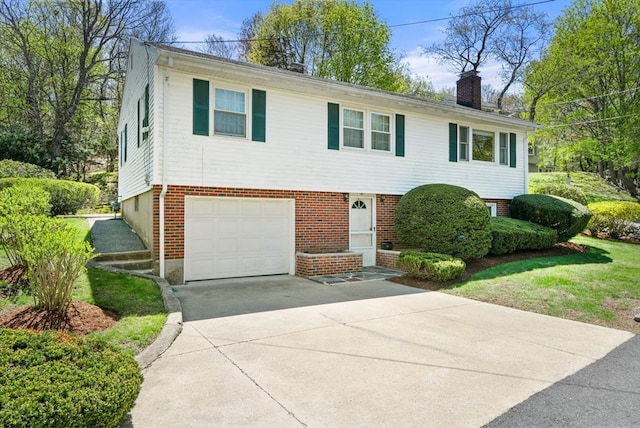 view of front of house featuring brick siding, a garage, driveway, and a chimney