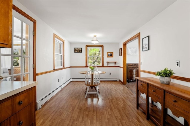 dining area featuring a baseboard heating unit and light wood-style flooring