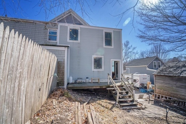 back of property featuring a wooden deck and fence