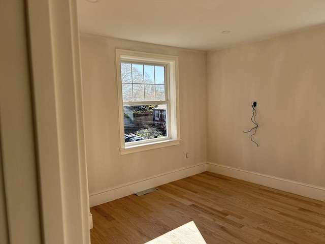 empty room with visible vents, baseboards, and wood finished floors