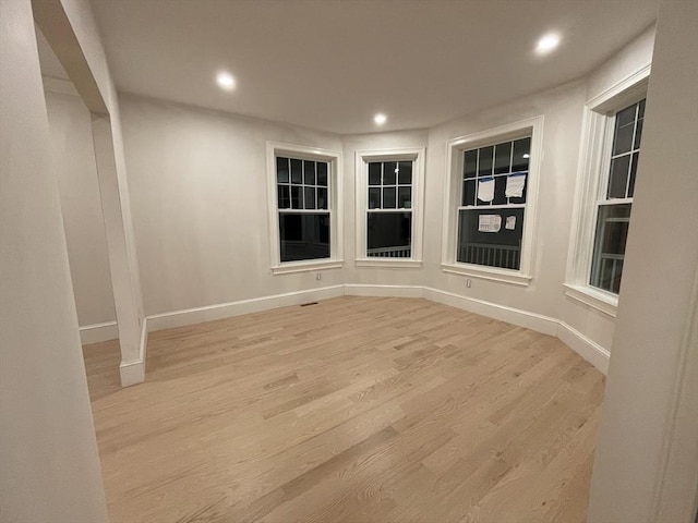 empty room with baseboards, light wood-type flooring, and recessed lighting