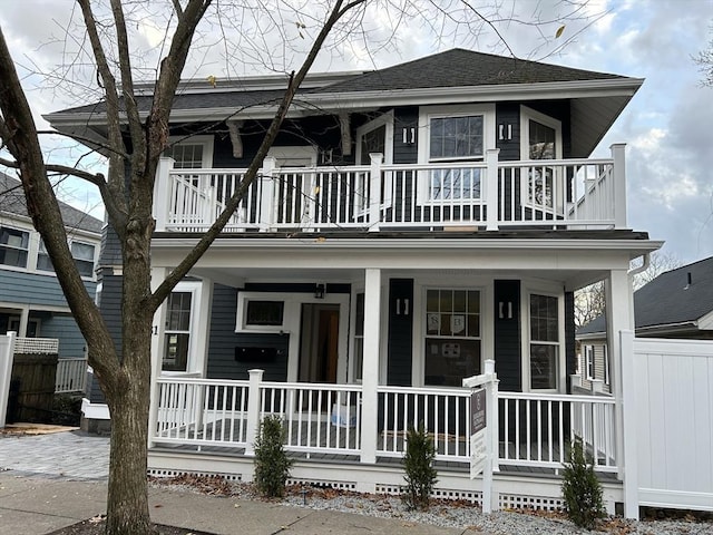 view of front of property with a porch, a shingled roof, and a balcony