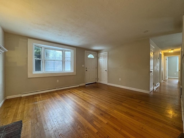 2248 Washington St, East Bridgewater, MA 02333 - foyer with a textured ceiling, baseboard heating, wood-type flooring, and baseboards