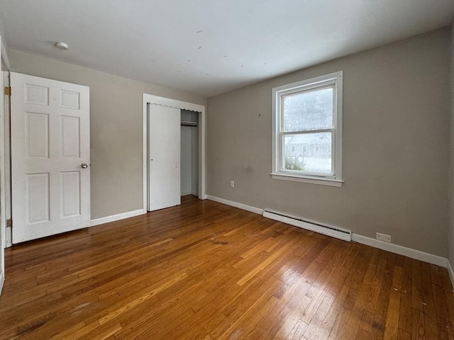 2248 Washington St, East Bridgewater, MA 02333 - unfurnished bedroom with a baseboard radiator, baseboards, wood-type flooring, and a closet