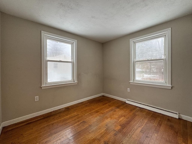 2248 Washington St, East Bridgewater, MA 02333 - spare room with baseboards, a textured ceiling, a baseboard heating unit, and hardwood / wood-style floors