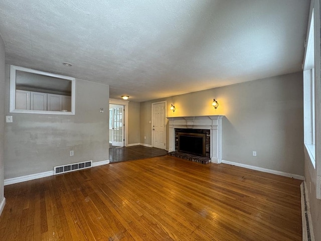 2248 Washington St, East Bridgewater, MA 02333 - unfurnished living room with a fireplace with raised hearth, hardwood / wood-style flooring, visible vents, and baseboards
