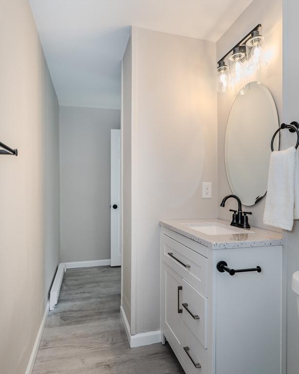 bathroom featuring vanity, baseboards, and wood finished floors