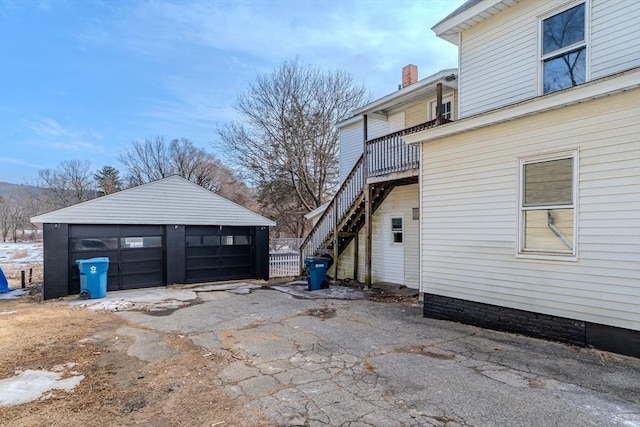 view of home's exterior featuring a garage, stairway, and an outdoor structure