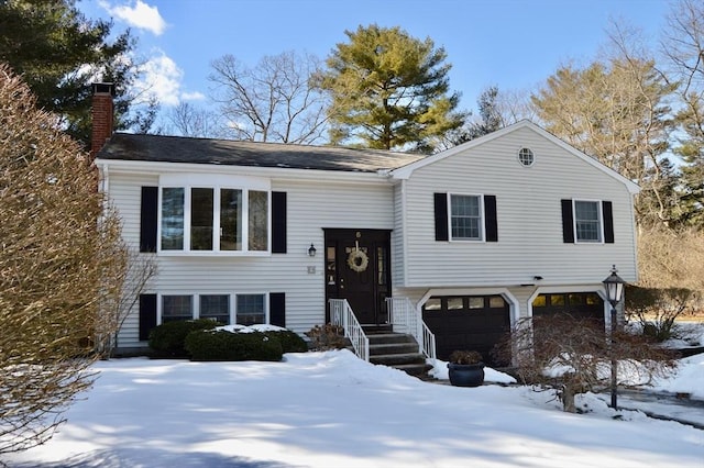 split foyer home with an attached garage and a chimney