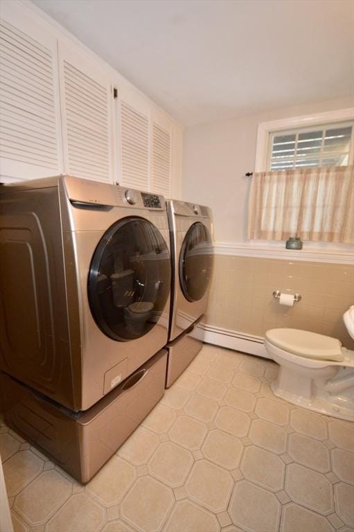 laundry room with laundry area, a baseboard radiator, light tile patterned floors, and independent washer and dryer