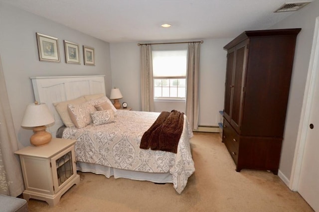 bedroom featuring a baseboard heating unit, light colored carpet, and visible vents