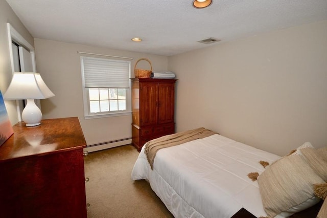 carpeted bedroom featuring a baseboard heating unit, visible vents, and recessed lighting