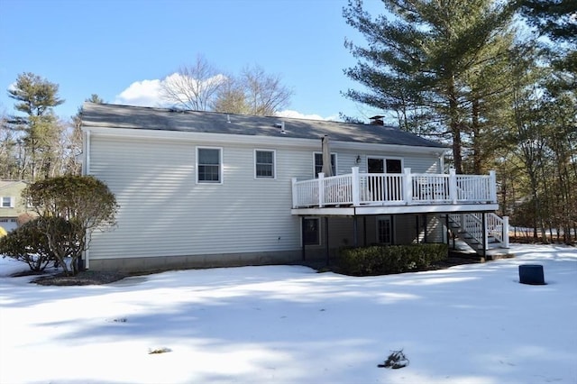 snow covered rear of property featuring a deck and stairway