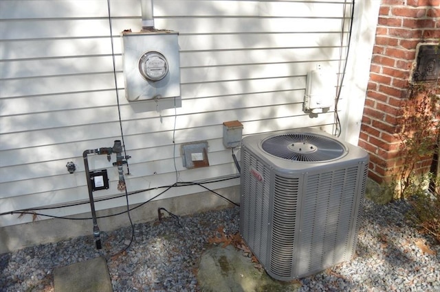 details with electric meter, brick siding, and central air condition unit