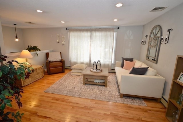 living room featuring visible vents, a baseboard radiator, light wood-style flooring, a baseboard heating unit, and recessed lighting