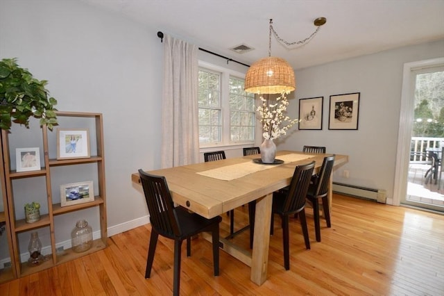 dining room with a baseboard radiator, visible vents, light wood-style flooring, and baseboards