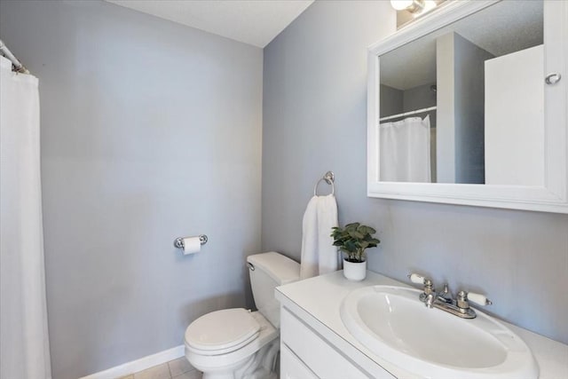 bathroom featuring tile patterned floors, baseboards, toilet, and vanity