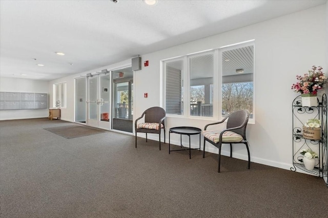 sitting room with a wealth of natural light, french doors, baseboards, and carpet floors