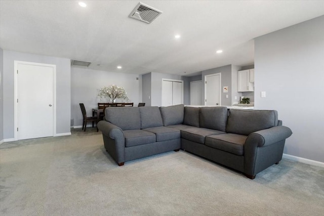 living area featuring baseboards, recessed lighting, visible vents, and light carpet