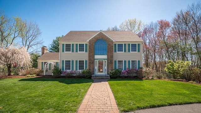 colonial-style house with a front yard and a chimney