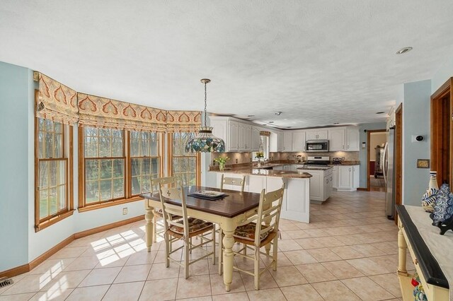 dining space featuring light tile patterned floors, baseboards, and recessed lighting