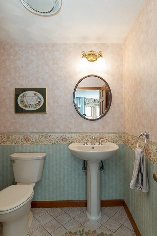 half bathroom with tile patterned floors and toilet