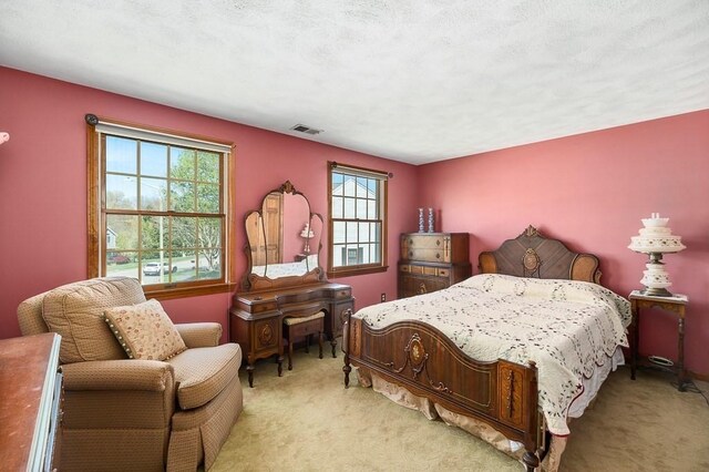 bedroom with multiple windows and light colored carpet