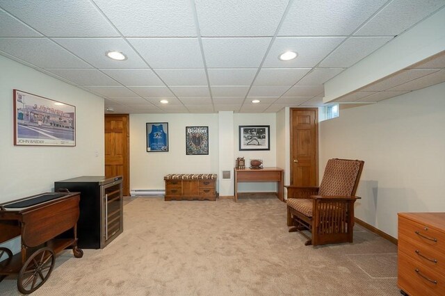 living area featuring a baseboard heating unit, carpet flooring, recessed lighting, a drop ceiling, and baseboards