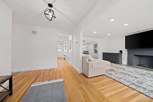 359 Corey St, Boston, MA 02132 - living area with arched walkways, wood finished floors, recessed lighting, a fireplace, and baseboards