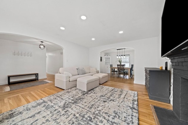 359 Corey St, Boston, MA 02132 - living room featuring arched walkways, light wood finished floors, recessed lighting, a chandelier, and baseboards