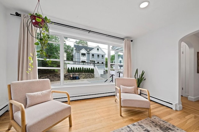 359 Corey St, Boston, MA 02132 - living area featuring arched walkways, baseboard heating, wood finished floors, baseboards, and recessed lighting